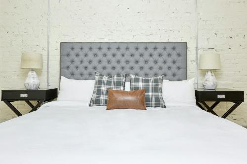 a large white bed with pillows and two lamps at Sonder by Marriott Bonvoy The Broughton Apartments Historic District in Savannah