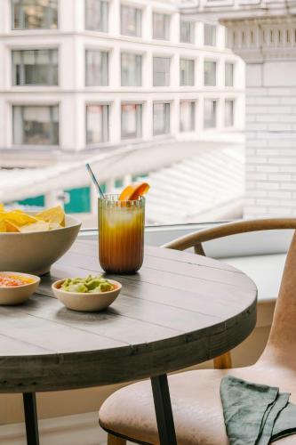 a table with a drink and bowls of food on it at Sonder by Marriott Bonvoy Jewelers Row Apartments Millenium Park in Chicago