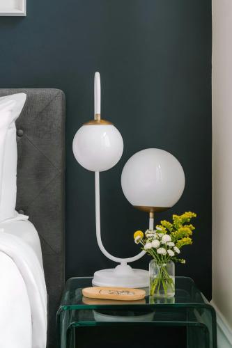 a table with a lamp and a vase of flowers on it at Sonder by Marriott Bonvoy Jewelers Row Apartments Millenium Park in Chicago