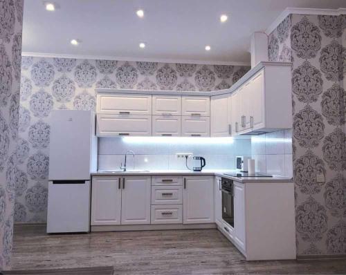 eine weiße Küche mit weißen Schränken und Geräten in der Unterkunft Apartment Tuska in Žabljak