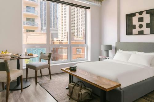 a bedroom with a bed and a table and a large window at Sonder by Marriott Bonvoy The Opal Apartments River North in Chicago