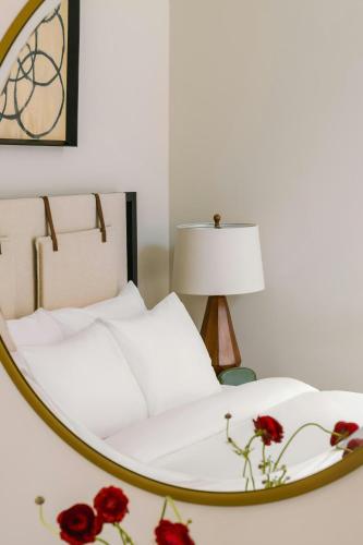 a mirror reflecting a bed with red roses on it at Sonder by Marriott Bonvoy Jewelers Row Apartments Millenium Park in Chicago