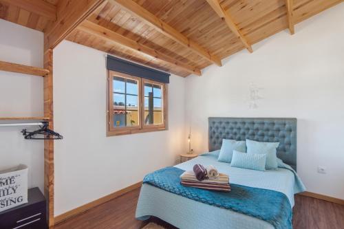 a bedroom with a bed with a blue headboard at Casinha Saragoça e Vergueiro in Ponte de Vagos