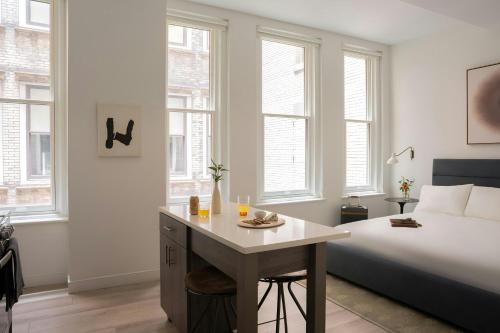 a bedroom with a bed and a desk and windows at Sonder by Marriott Bonvoy The Witherspoon Apartments Center City in Philadelphia