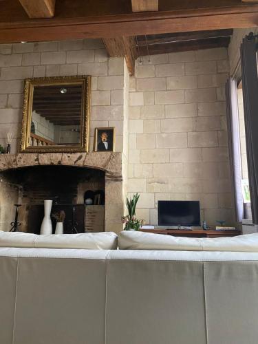 un canapé devant un mur de pierre avec un miroir dans l'établissement Hotel Robin Quantin Tours Center Place Plumereau, à Tours