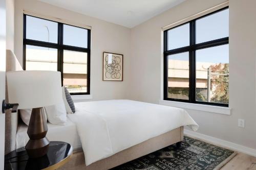 a white bedroom with a bed and windows at Sonder by Marriott Bonvoy The Edison Apartments Old City in Philadelphia