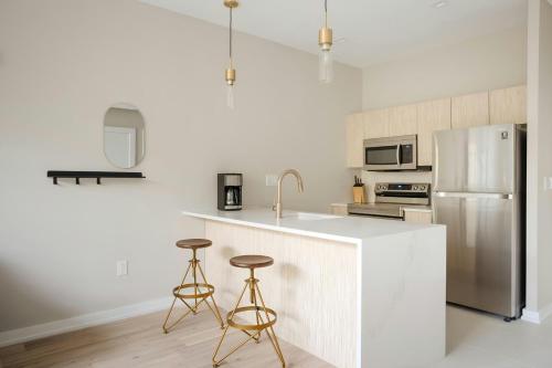 a kitchen with a refrigerator and two bar stools at Sonder by Marriott Bonvoy The Edison Apartments Old City in Philadelphia