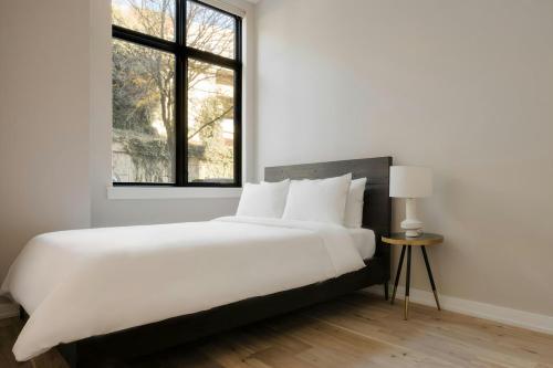 a white bedroom with a large bed and a window at Sonder by Marriott Bonvoy The Edison Apartments Old City in Philadelphia