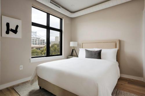 a white bedroom with a large bed and a window at Sonder by Marriott Bonvoy The Edison Apartments Old City in Philadelphia