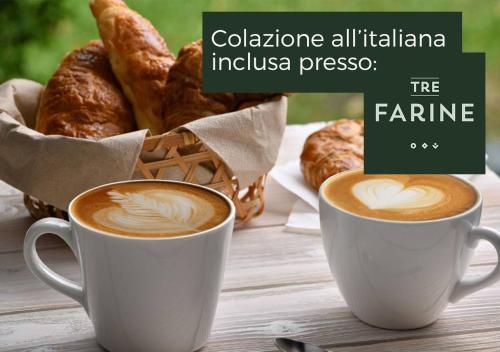 two cups of coffee and a basket of croissants at Residenza La Reggia in Caserta