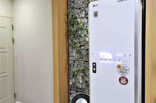 a wall with a plant on it next to a door at Gwangju Hanam 1st Hotel in Gwangju