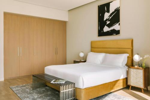 a bedroom with a large white bed and a table at Sonder by Marriott Bonvoy JBR The Walk Apartments in Dubai
