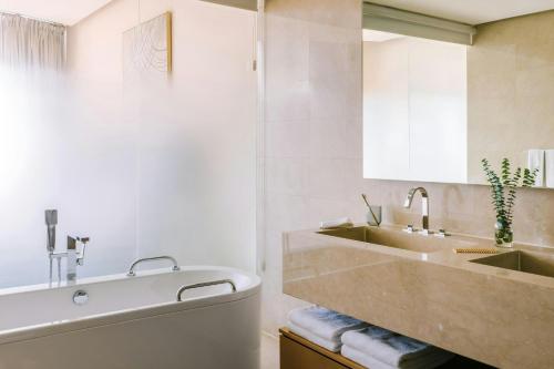 a bathroom with a tub and a sink at Sonder by Marriott Bonvoy JBR The Walk Apartments in Dubai