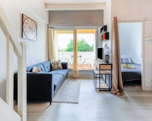 un salon avec un canapé bleu et une télévision dans l'établissement Palm Beach, au Cap d'Agde