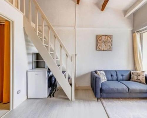 - un salon avec un canapé bleu et des escaliers dans l'établissement Palm Beach, au Cap d'Agde