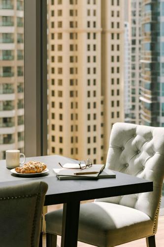 a table and a chair with a plate of food on it at Sonder by Marriott Bonvoy JBR The Walk Apartments in Dubai