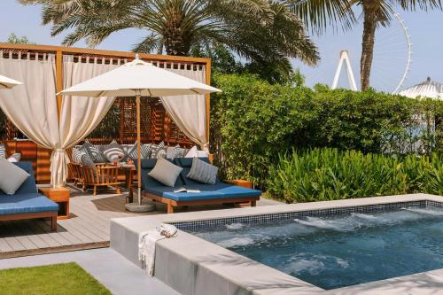 a swimming pool with chairs and an umbrella at Sonder by Marriott Bonvoy JBR The Walk Apartments in Dubai