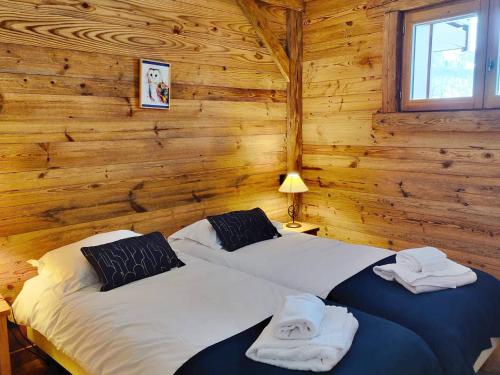 deux lits dans une chambre aux murs en bois dans l'établissement Appartement cosy avec piscine, spa et salle de sport, pied de pistes, 4-6 pers. - FR-1-461-22, à Saint-Martin-de-Belleville