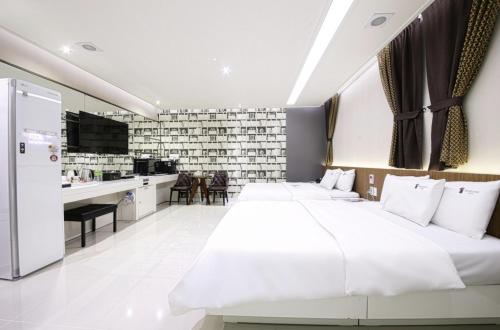 a hotel room with two beds and a kitchen at Gwangju Hanam 1st Hotel in Gwangju