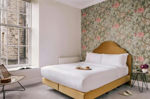 a bedroom with a large bed with a floral wallpaper at Thistle Suites Royal Garden in Edinburgh