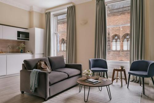a living room with a couch and a table at Thistle Suites Royal Garden in Edinburgh