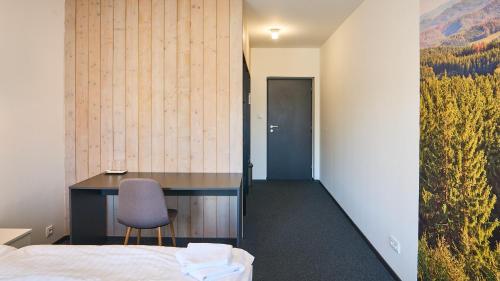 a bedroom with a desk and a bed and a chair at Pivovar Falkenštejn in Krásná Lípa