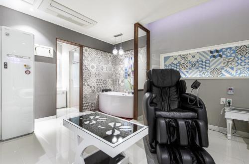 a bathroom with a black chair and a glass table at Gwangju Hanam 1st Hotel in Gwangju