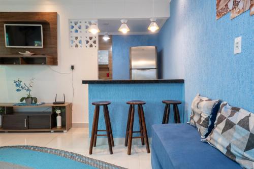 una sala de estar con una pared azul y taburetes en Apto com Wi-Fi a 950m da Praia da Tartaruga, en Rio das Ostras