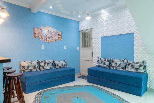 una sala de estar con 2 sofás azules en una habitación en Apto com Wi-Fi a 950m da Praia da Tartaruga, en Rio das Ostras