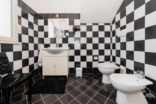 a bathroom with a black and white checkered wall at CASA PAPADIA in Uggiano la Chiesa