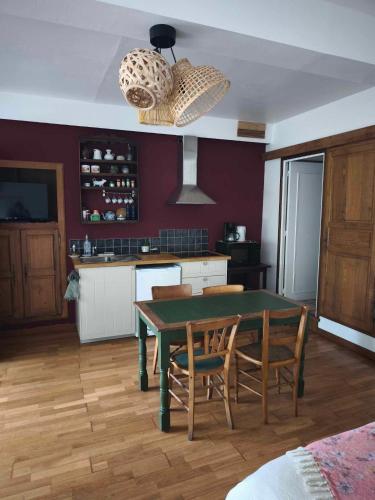 une cuisine avec une table et des chaises dans une pièce dans l'établissement Gîte de La Bacouette, à Le Vey