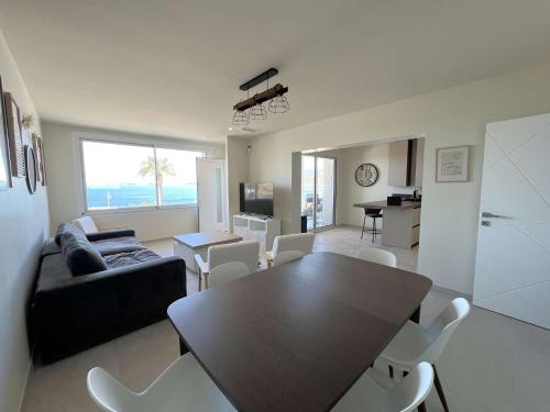 un salon avec un canapé, une table et des chaises dans l'établissement Le Rivage Appartement climatisé pour 6 personnes face à la mer- Le Pradet, au Pradet
