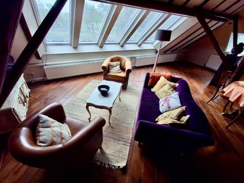 a living room with two couches and a table at Apartment Noorderloft in Hornhuizen