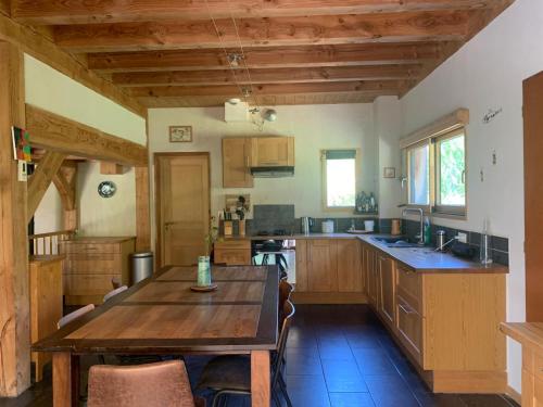 une cuisine avec des armoires en bois et une table en bois dans l'établissement Jolie maison en bois avec piscine, à Saint-Césaire-de-Gauzignan