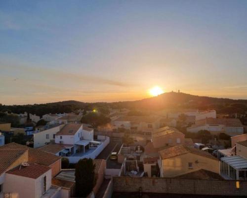 un coucher de soleil sur une ville avec des maisons et des bâtiments dans l'établissement Love flat, au Cap d'Agde
