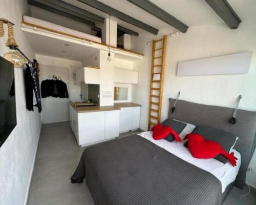 une chambre avec un grand lit avec des oreillers rouges dans l'établissement Love flat, au Cap d'Agde