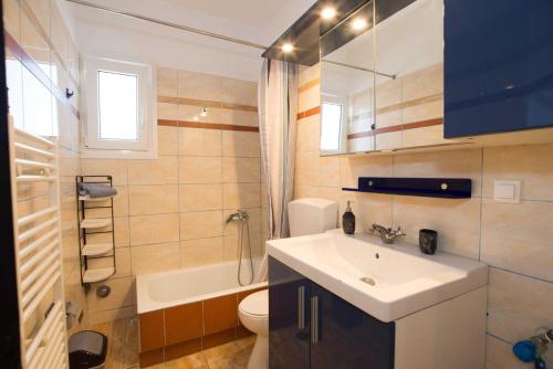 a bathroom with a sink and a toilet and a tub at PAROS APARTMENT MELAS a2 in Parikia