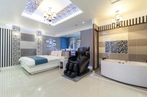 a bedroom with a bed and a tub and a chair at Gwangju Hanam 1st Hotel in Gwangju