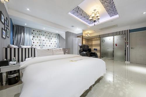 a bedroom with a large white bed and a desk at Gwangju Hanam 1st Hotel in Gwangju
