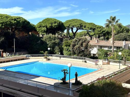 une grande piscine avec des arbres en arrière-plan dans l'établissement HYEPHI T2 pour 4 personnes dans résidence avec piscine - Hyères Port, à Hyères