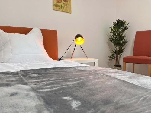 una camera da letto con un letto con una lampada e una sedia di Loftartiges Appartment in Magdeburg, 2 Schlafzimmer, Küche und Bad - B a Magdeburgo
