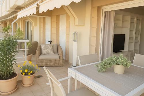 une terrasse avec une table, des chaises et une télévision dans l'établissement Palais Florentin - Prime location -150m Casino gardens - Panoramic Sea View - Large Terrace - Parking, à Beausoleil