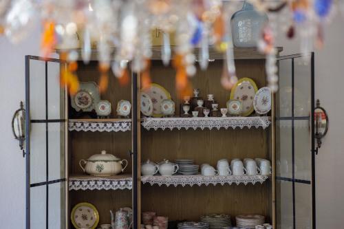 a cupboard filled with dishes and china at Hôtel La Villa Sainte Valérie Adults Only in Juan-les-Pins