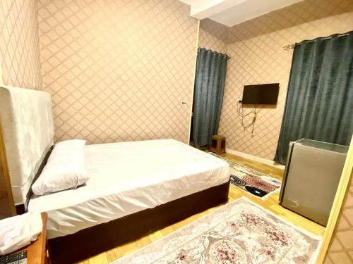 a small bedroom with a bed and a television at sphinx one centre hotel in Banī Ghālib