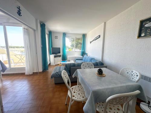 un salon avec une table et un canapé dans l'établissement Emplacement idéal à Port Camargue, au Grau-du-Roi