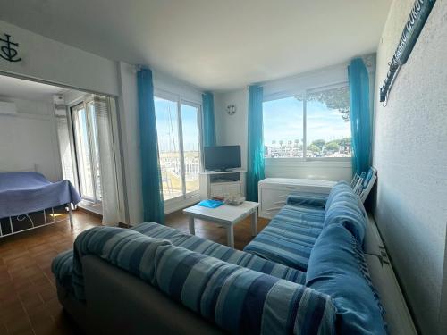 un salon avec un canapé bleu et une télévision dans l'établissement Emplacement idéal à Port Camargue, au Grau-du-Roi