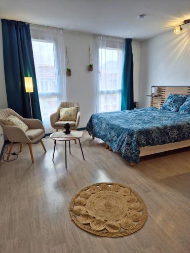 une chambre avec un lit, une chaise et une table dans l'établissement Sérénité - Spacieux - Vue - Equipé, à Lourdes