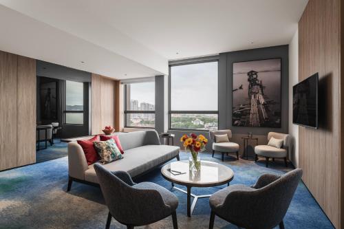 a living room with a couch and chairs and a table at Crowne Plaza Penang Straits City by IHG in Perai