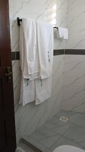 a bathroom with white towels hanging on a wall at Greenfield Villa D- Diani in Kwale