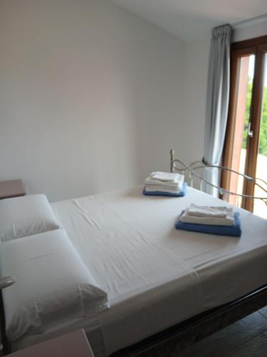 a bed with two towels sitting on top of it at Ottiolu House villa 50m from beach in Porto Ottiolu